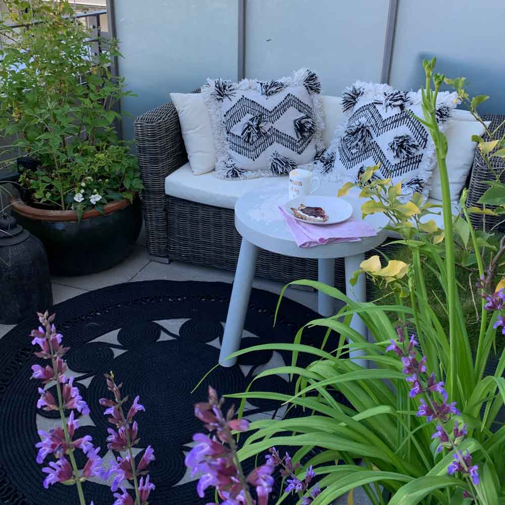 Outdoor Deko mit Teppich und Kissen und Licht. Teppiche für draußen aus wetterfestem PET & weiche Kissen & Windlicht & Lampe | Outdoor Teppich im Boho Stil