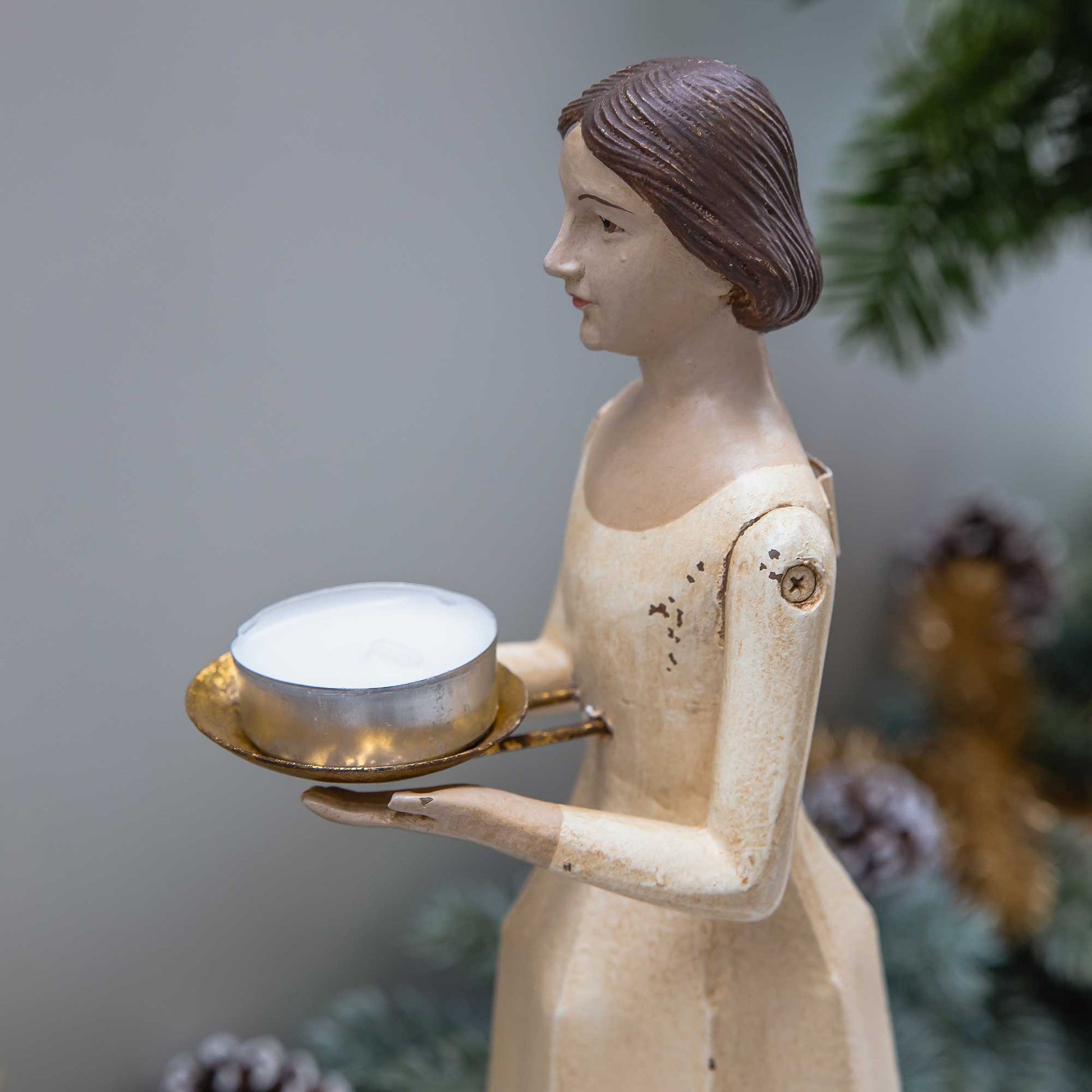 Gelber Engel im Vintage Stil der ein Teelicht in den Händen hält auf einer goldenen Schale.