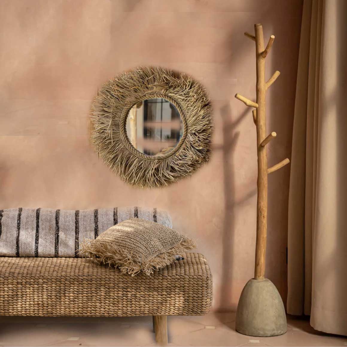 Handgeflochtener runder Naturgras-Spiegel Tahiti an einer hellen Wand im Flur Boho Interior Design.