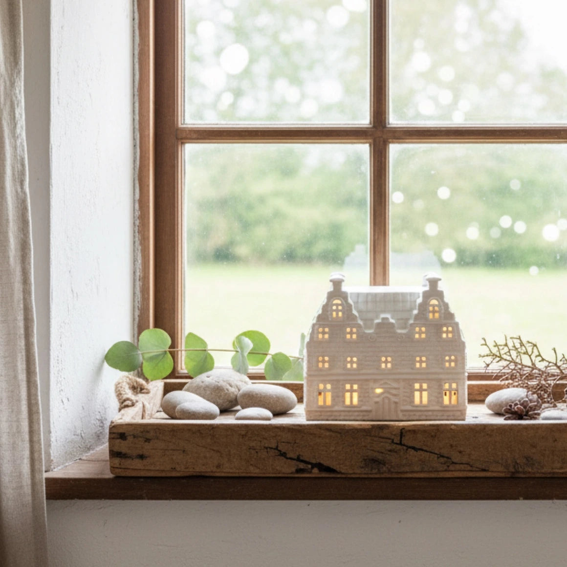 Großes Lichthaus auf Dekotablett aus Holz beleuchtet dekoriert im Wohnzimmer