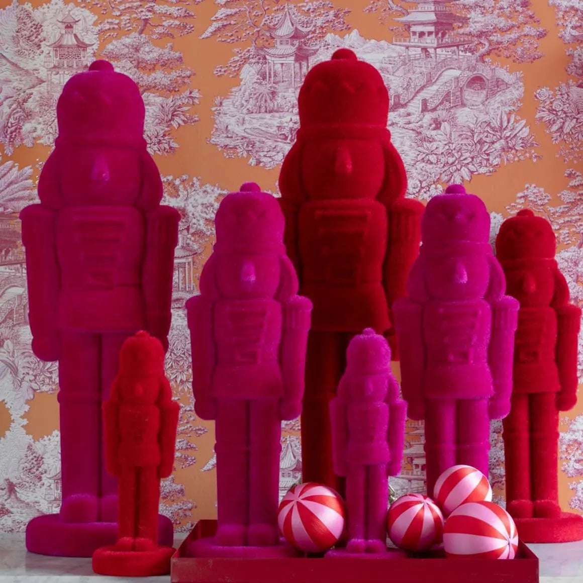 Moderne rote Nussknacker mit Samtoberfläche als knallige trendige Weihnachtsfigur im Wohnzimmer