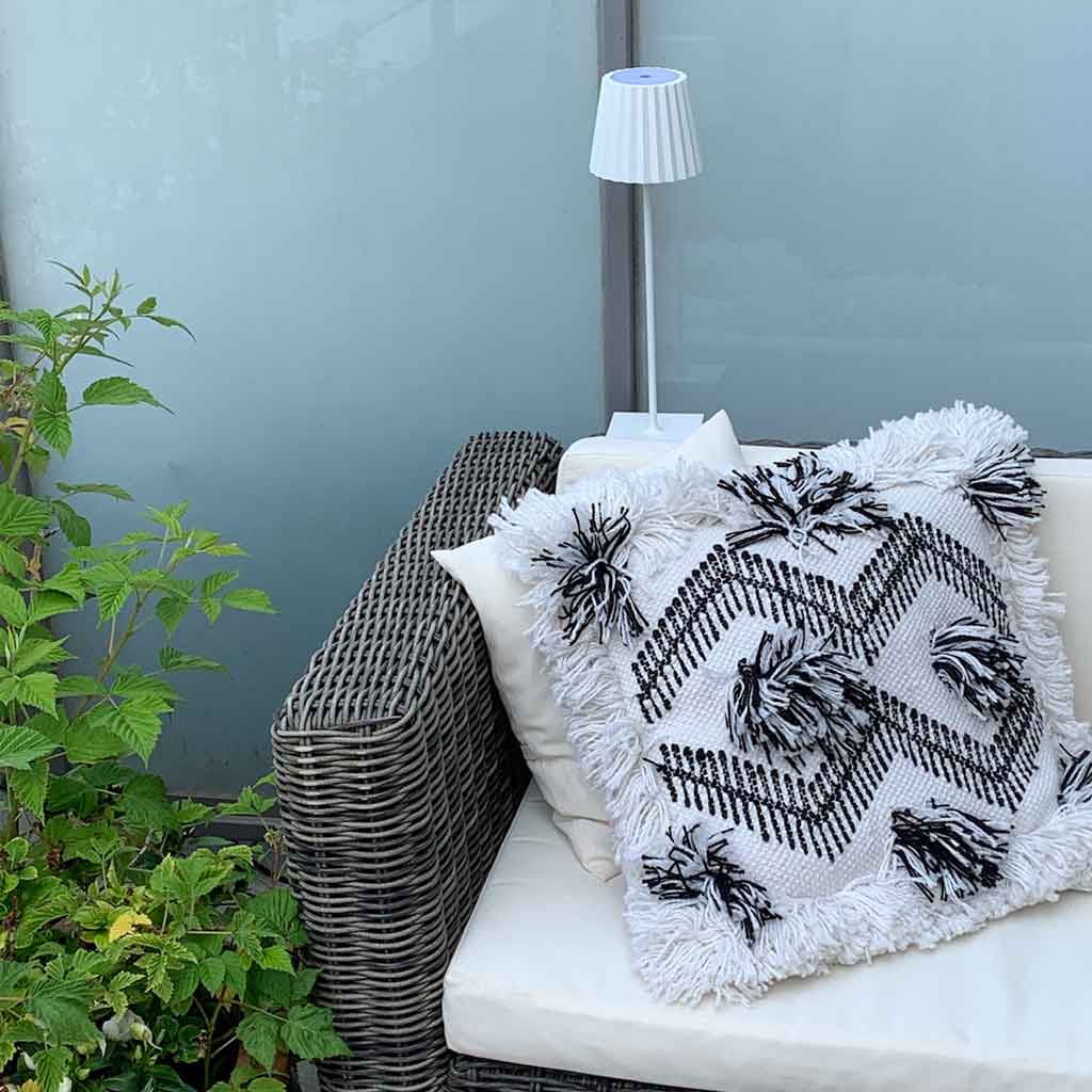 Outdoor Deko mit Teppich und Leseleuchte für den Balkon und die Terrasse. Dazu passende Kissen im Boho Stil und im skandinavischen Stil. Outdoor Lampe mit Akku ohne Kabel