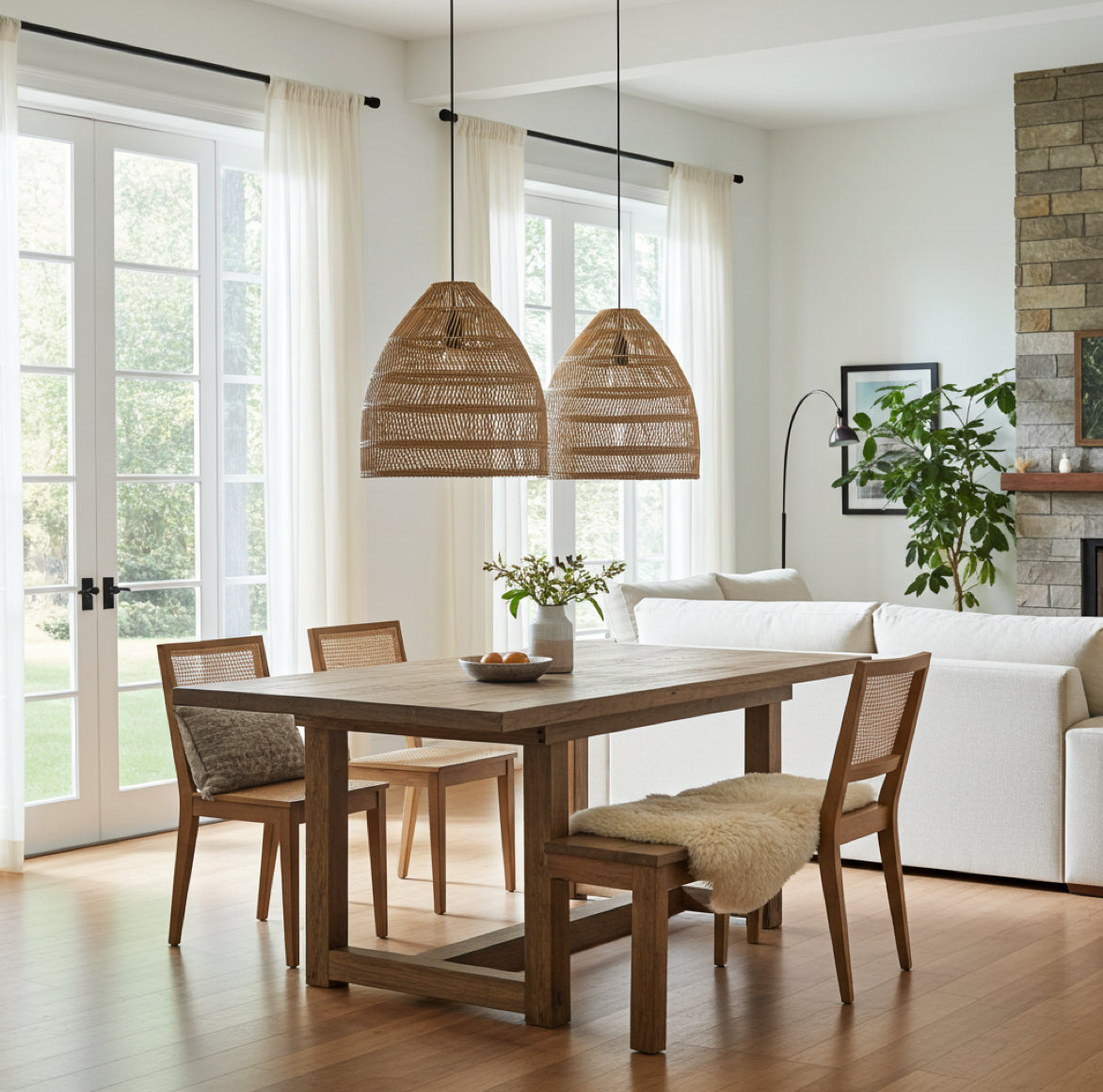 Braune Rattan Lampe MAJA als Esstischbeleuchtung in einem hellen Wohnzimmer im Boho- und Skandi-Stil.