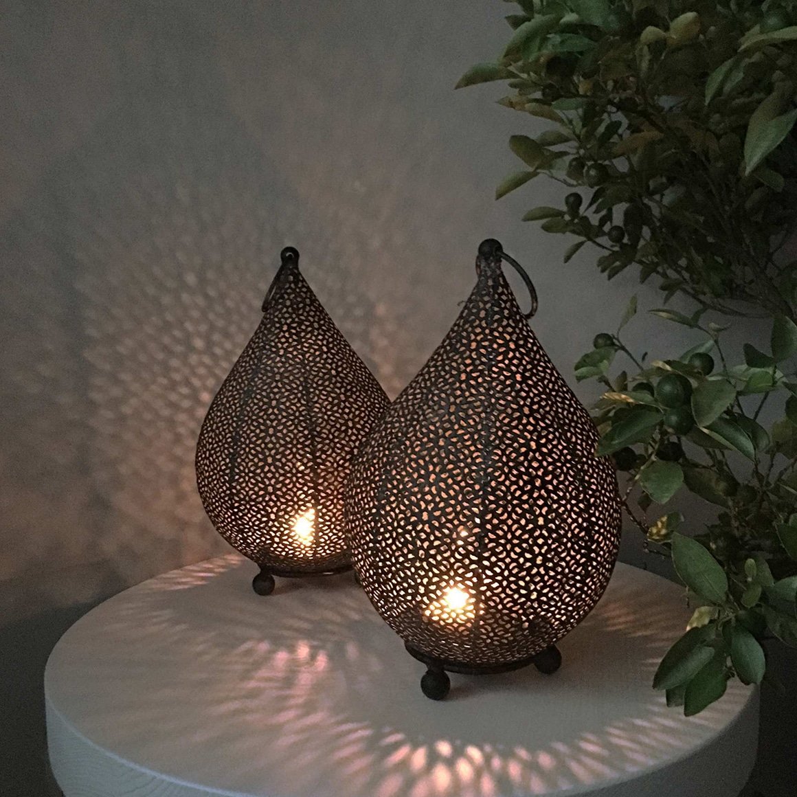 Orientalisches Windlicht in Schwarz, wirft durch sein Lochmuster ein Schattenspiel an die Wand. Es leuchtet besonders schön auf Terrasse und Garten!