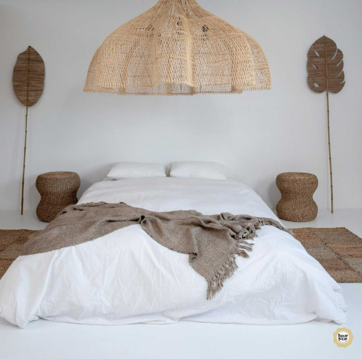 Große Boho Rattan-Hängelampe über einem minimalistischen Bett im natürlichen Schlafzimmer.
