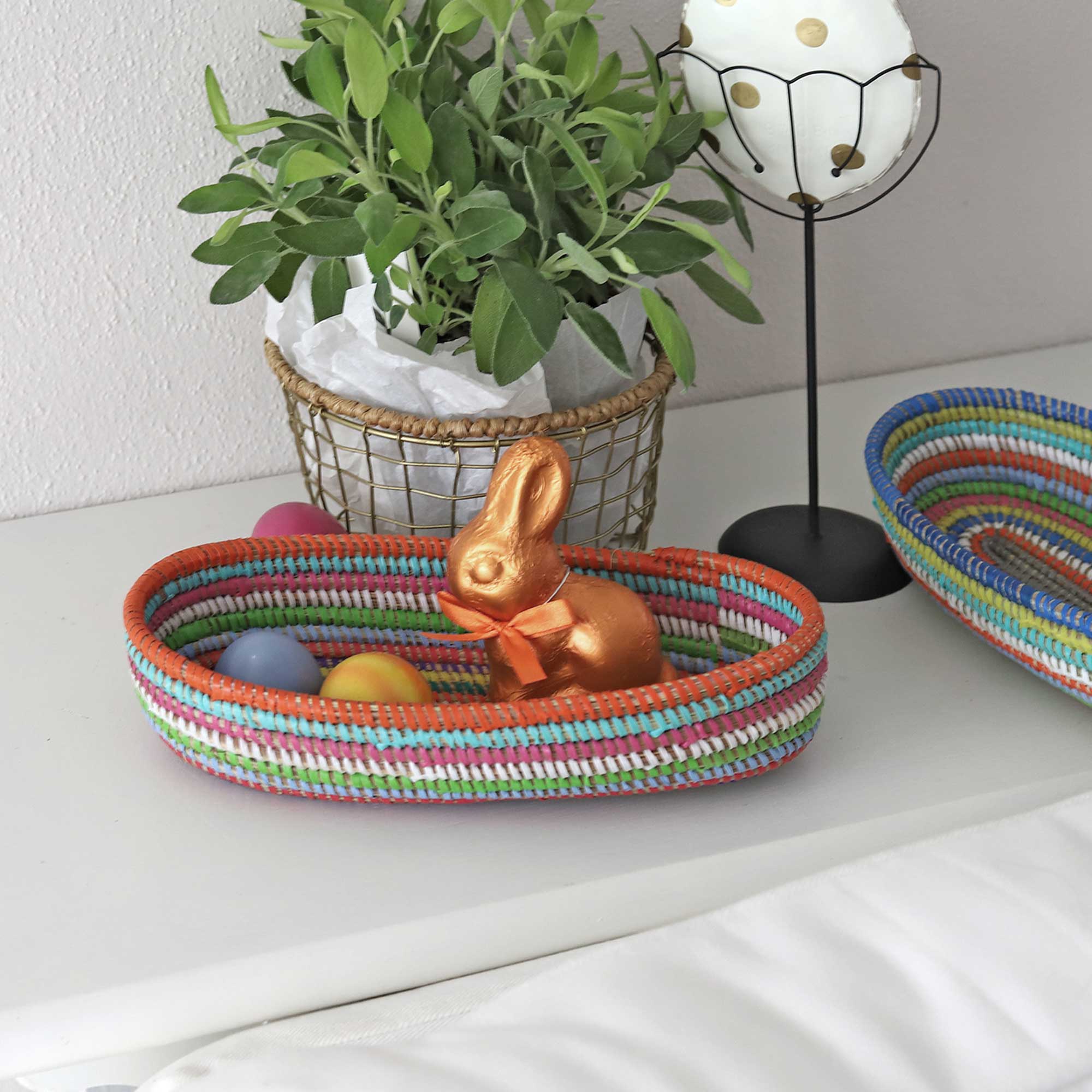 Buntes Osternest Afrikanisches Körbchen aus Savannen-Gras mit geringelten Plastikbändern. Osterdeko 2023 online kaufen, Soulbirdee