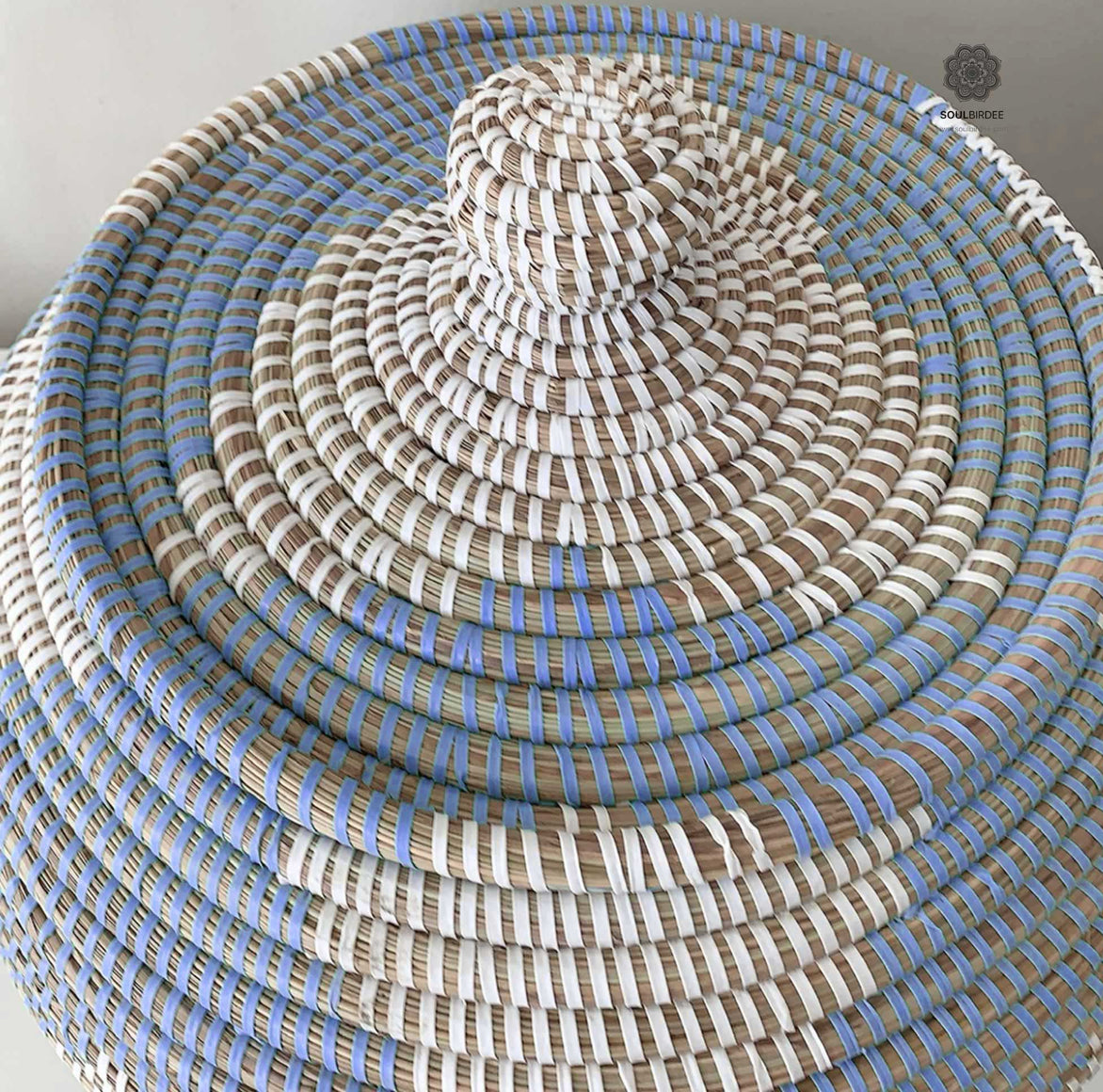 Nahaufnahme des handgeflochtenen Musters aus Savannengras und weißem Plastikband beim Korb Blau Weiss