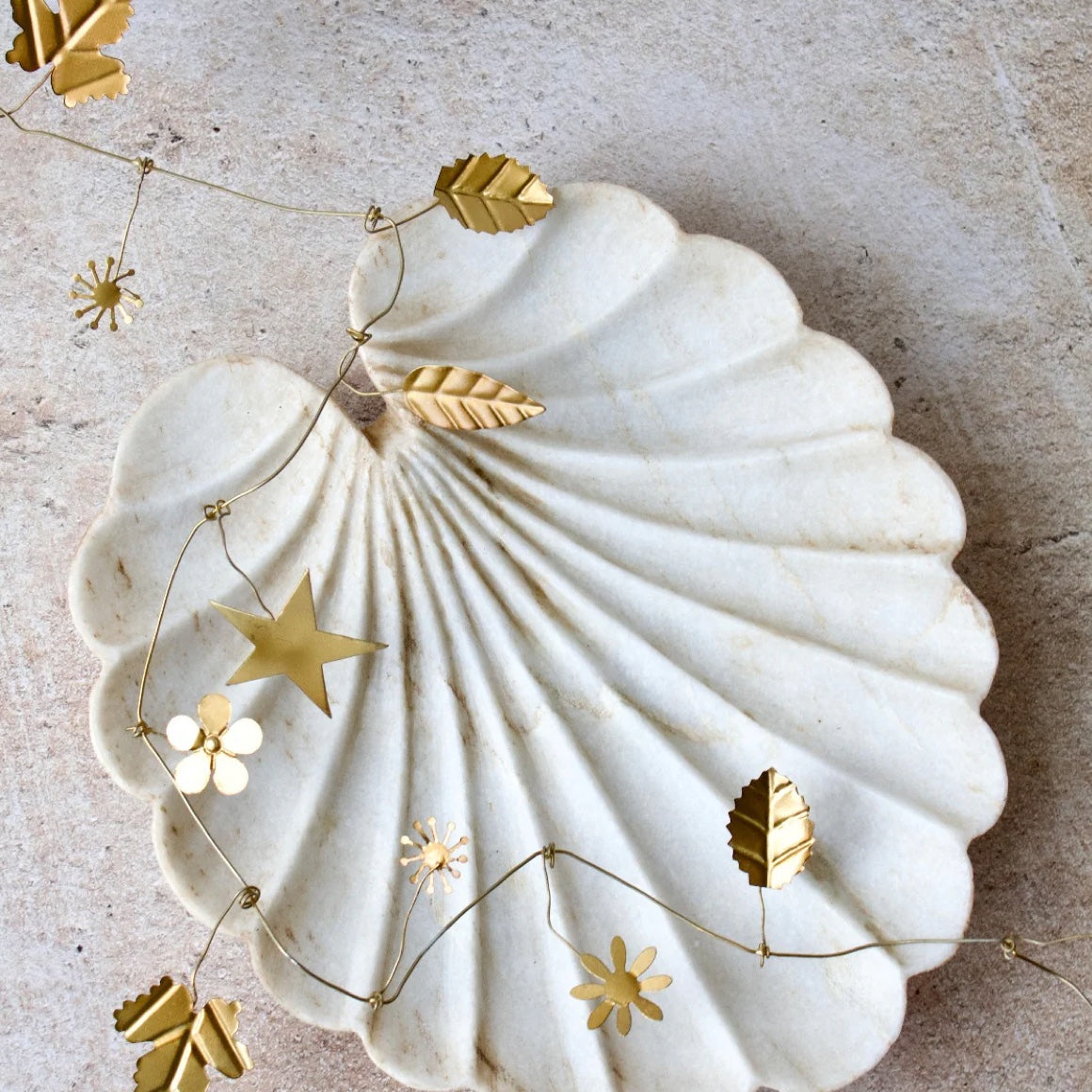 goldene girlande im boho stil aus metall mit handgefertigten blättern, sternen und blumen als tischdeko für kranz weldaad