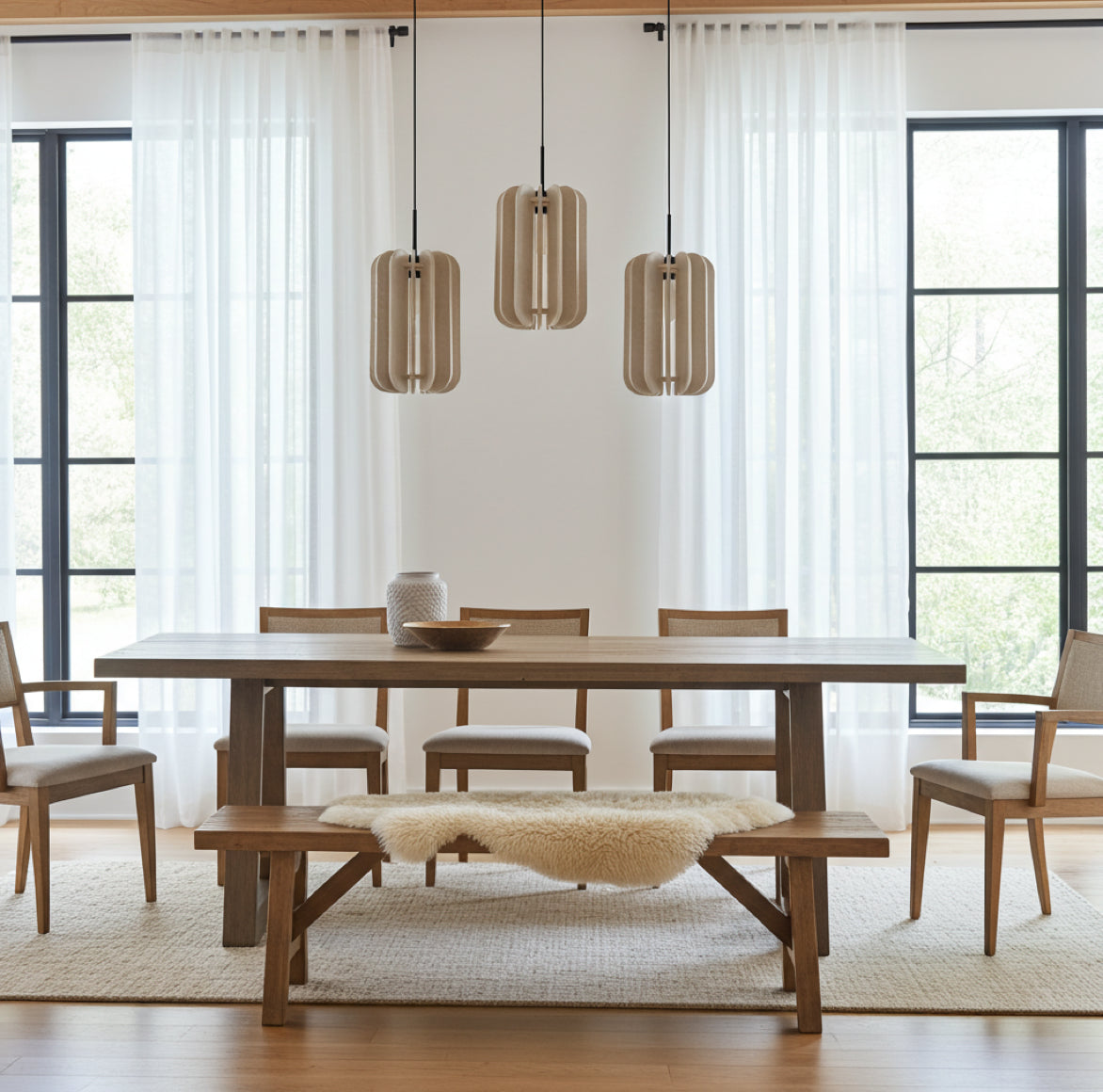 3 Hängelampen in Beige aus Filz mit Lamellen im modernen Design über einem Esstisch im Esszimmer