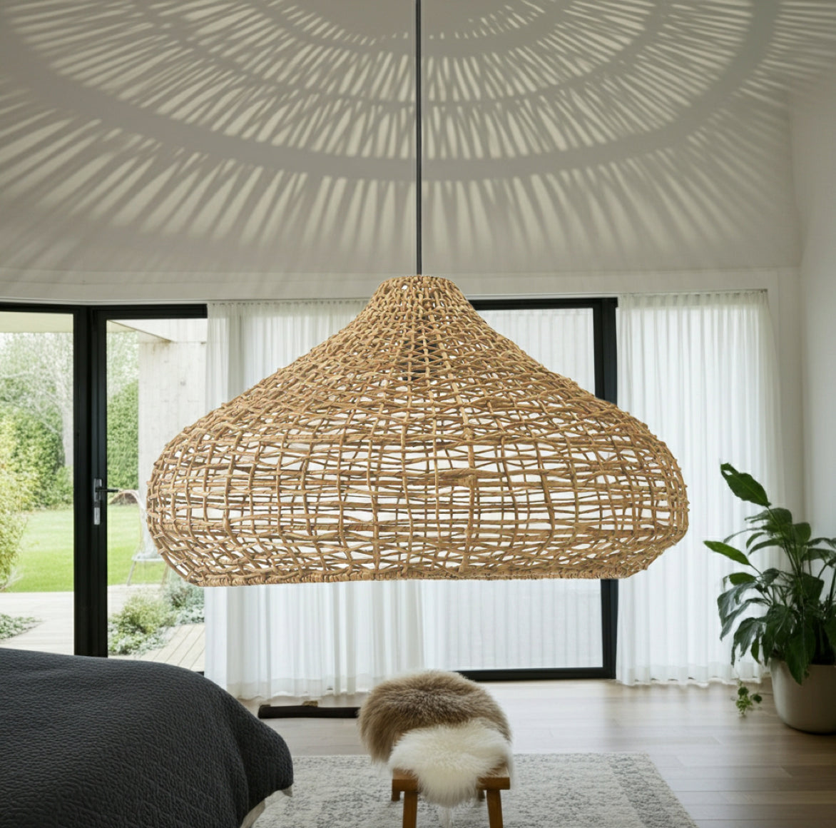 Eingeschaltete Rattan-Stil Lampe Mira zeigt dekorative Licht- und Schattenmuster an der Zimmerdecke und den Wänden.