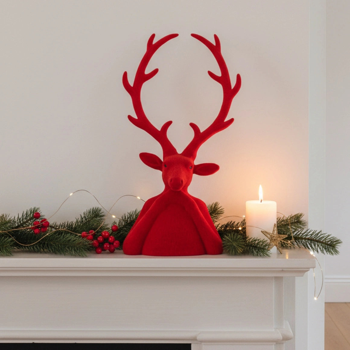 Roter Samt Hirsch als weihnachtliche Deko auf dem Kaminsims im Winter