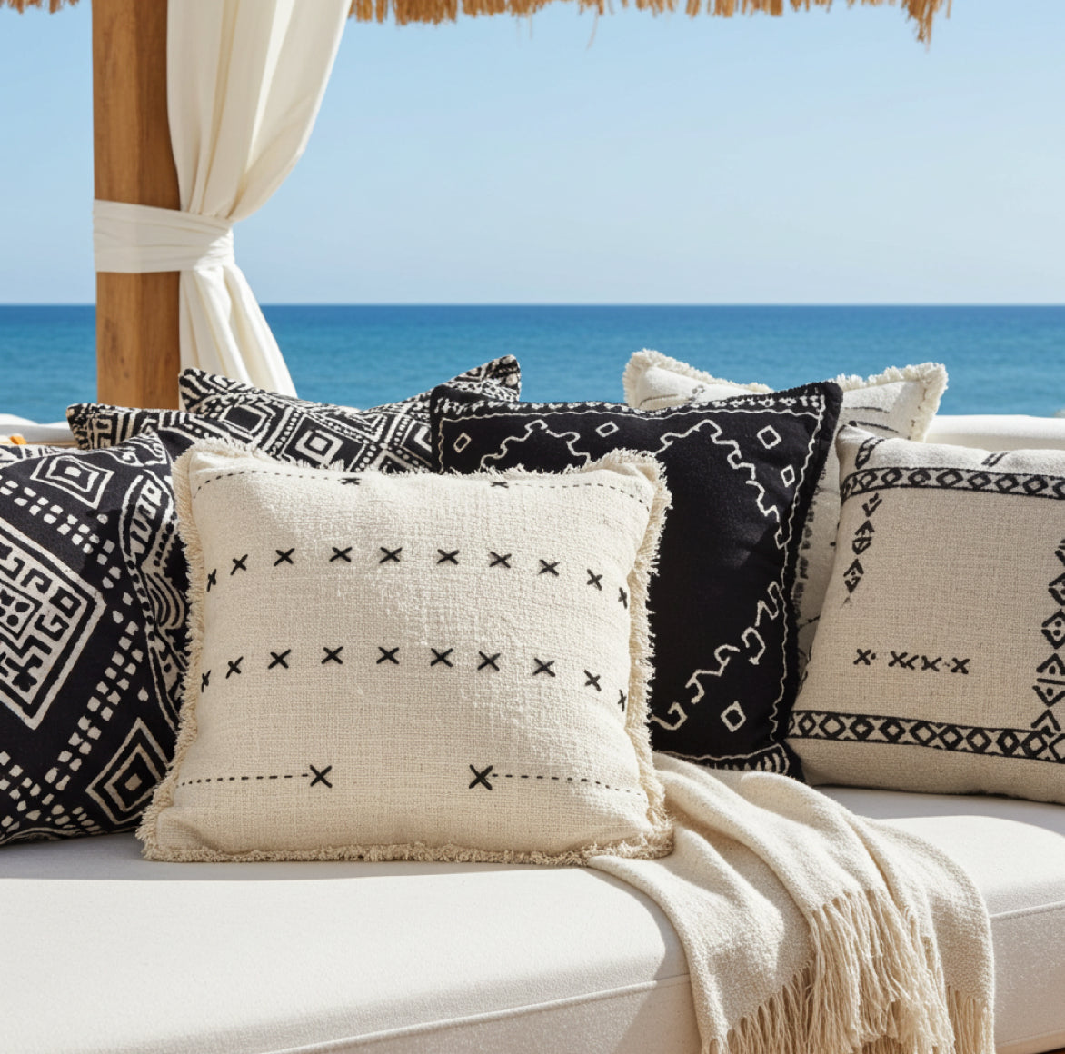 Boho Kissen beige mit muster schwarz gestickt als zierkissen auf einem sofa mit schwarz gemusterten Kissen