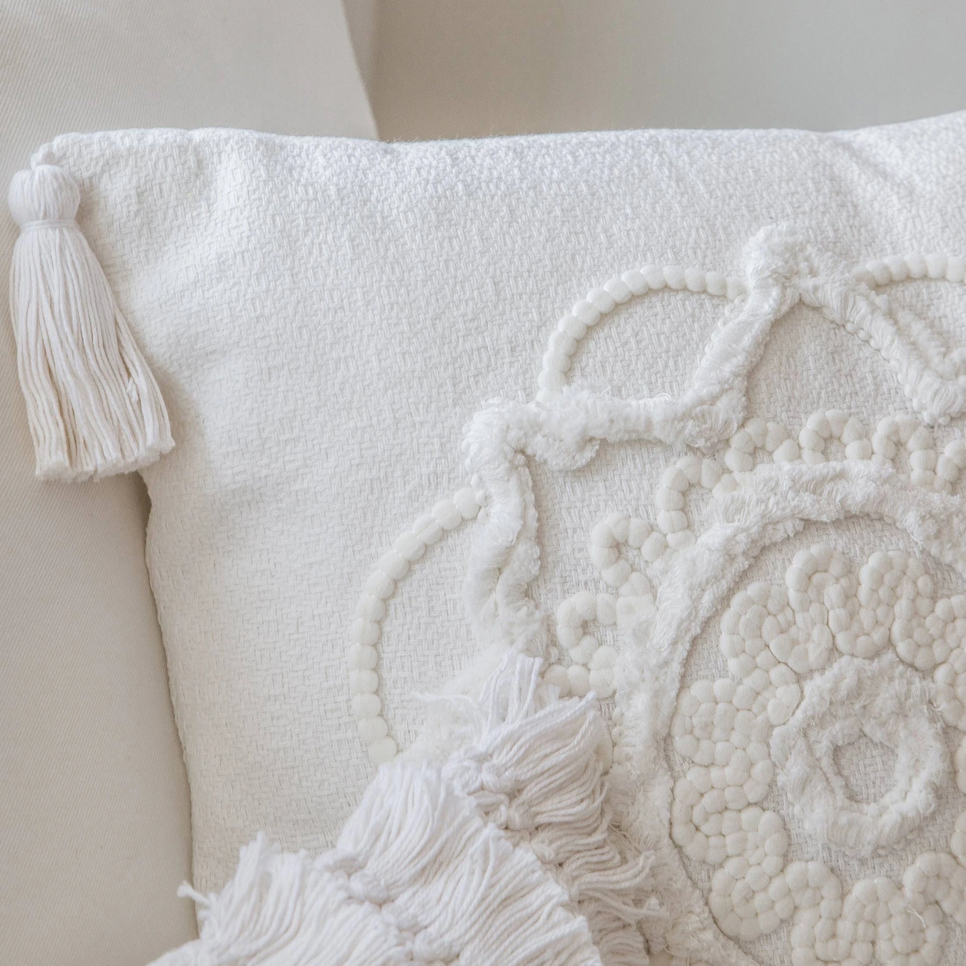 Nahaufnahme der handgefertigten Stickerei des quadratischen Boho-Kissens Capri mit Bommel