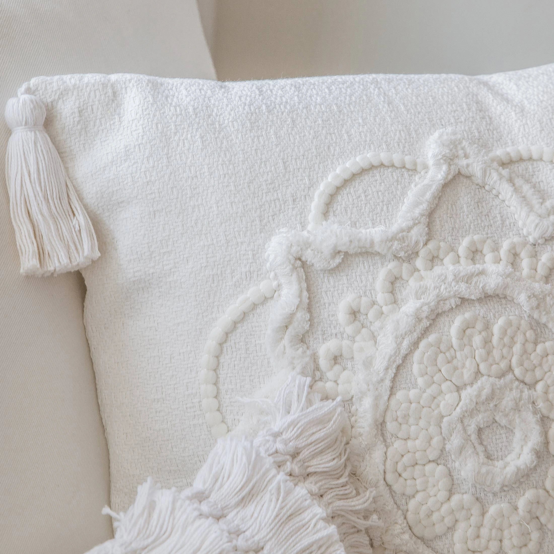 Nahaufnahme der handgefertigten Stickerei des quadratischen Boho-Kissens Capri mit Bommel