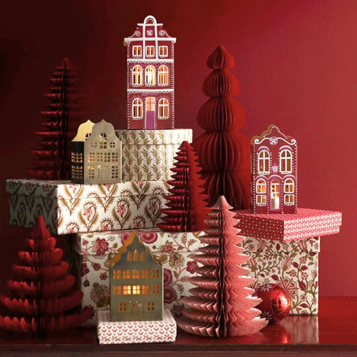 Rotes Lebkuchenhaus Scarlet aus Metall mit handbemalter Fassade und warmem goldenen Innenlicht dekoriert in einer weihnachtlichen Szene