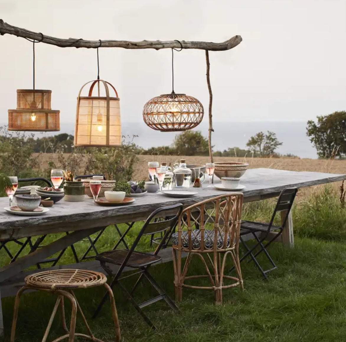 Sommerlicher Esstisch im Garten mit mehreren MADAME Bambusstühlen für ein sommerliches, cosmopolitisches Outdoor-Event.