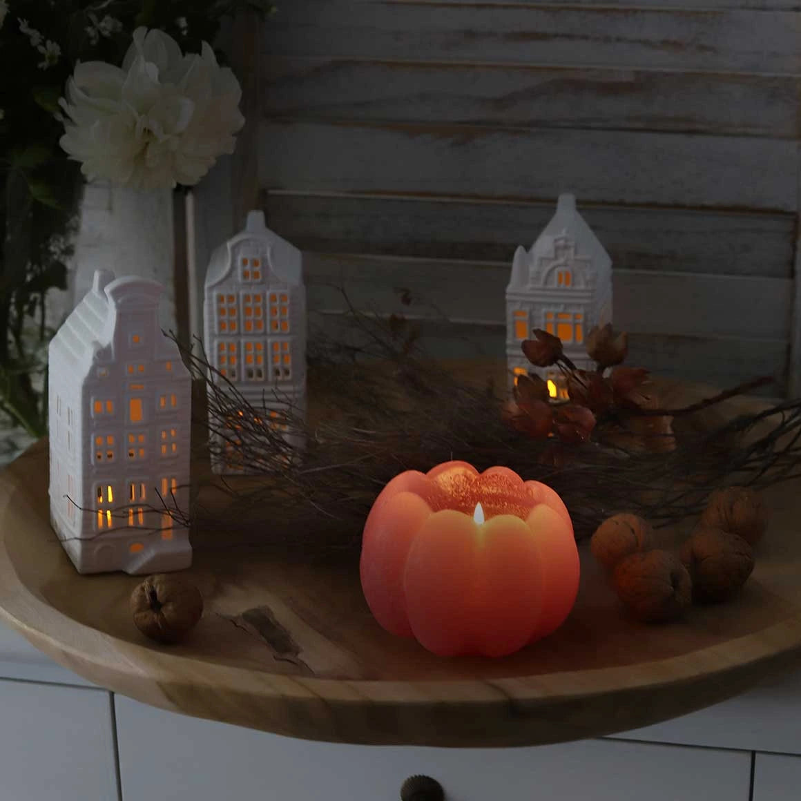 Weiße Lichthäuser aus Porzellan als Herbstdeko auf einem Dekotablett dekoriert