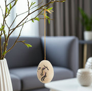 Hängendes Ei als Osterdeko an Zweigen mit einem Frau Gesicht handgemalt face von Madamstoltz Boho Osterei