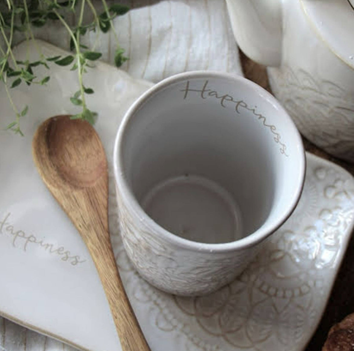Detailaufnahme der cremeweißen Reaktiv-Glasur am Rand der Tasse HAPPINESS.