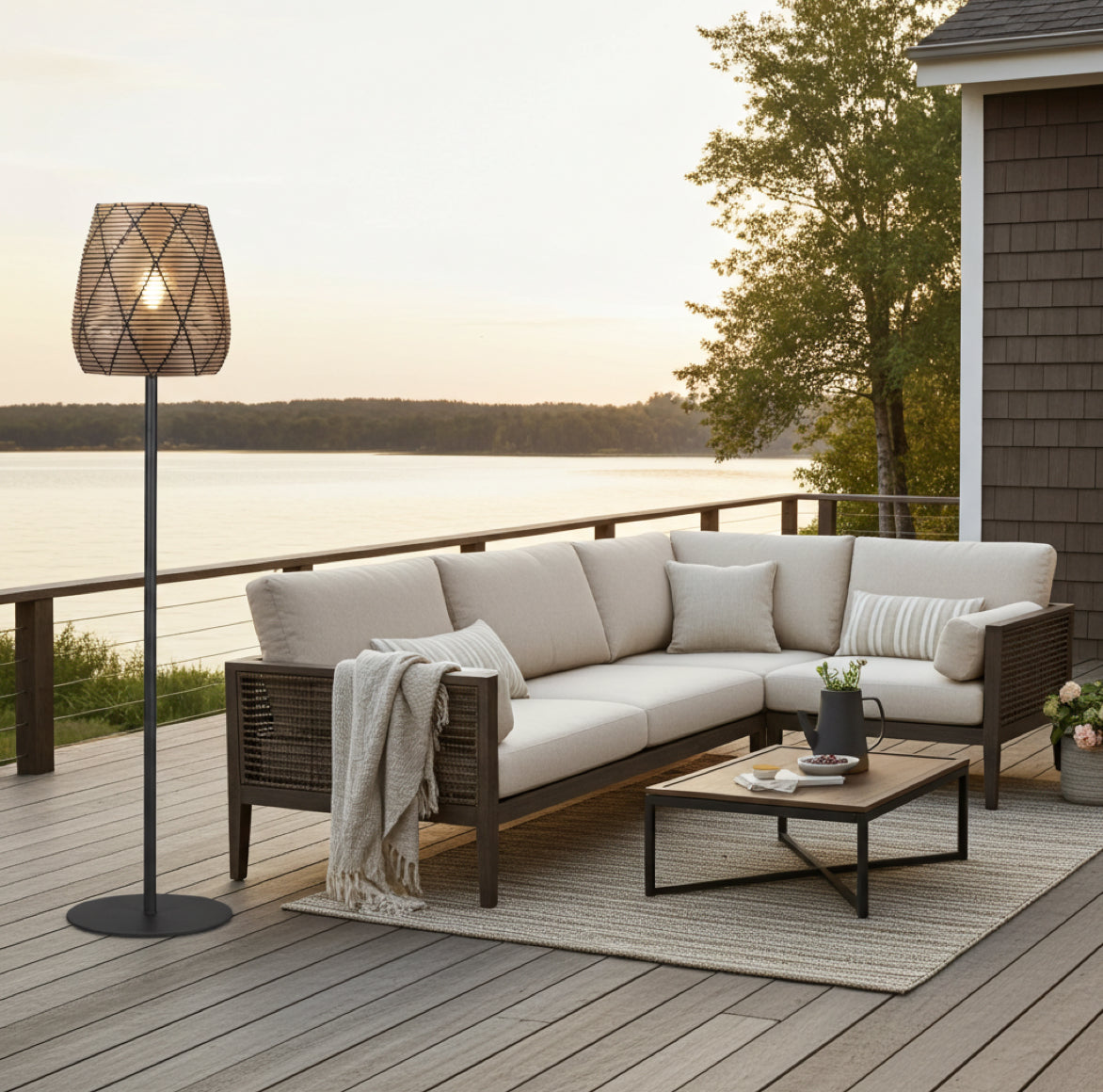Terrassenlampe im Landhaus Stil mit einem gemusterten polyrattan-Lampenschirm steht neben einem Sofa auf der Terrasse
