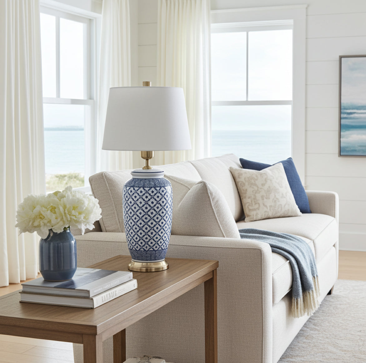 weiss-blaue Tischlampe aus Porzellan im Wohnzimmer im Hamptons Stil auf einem Tisch neben dem Sofa